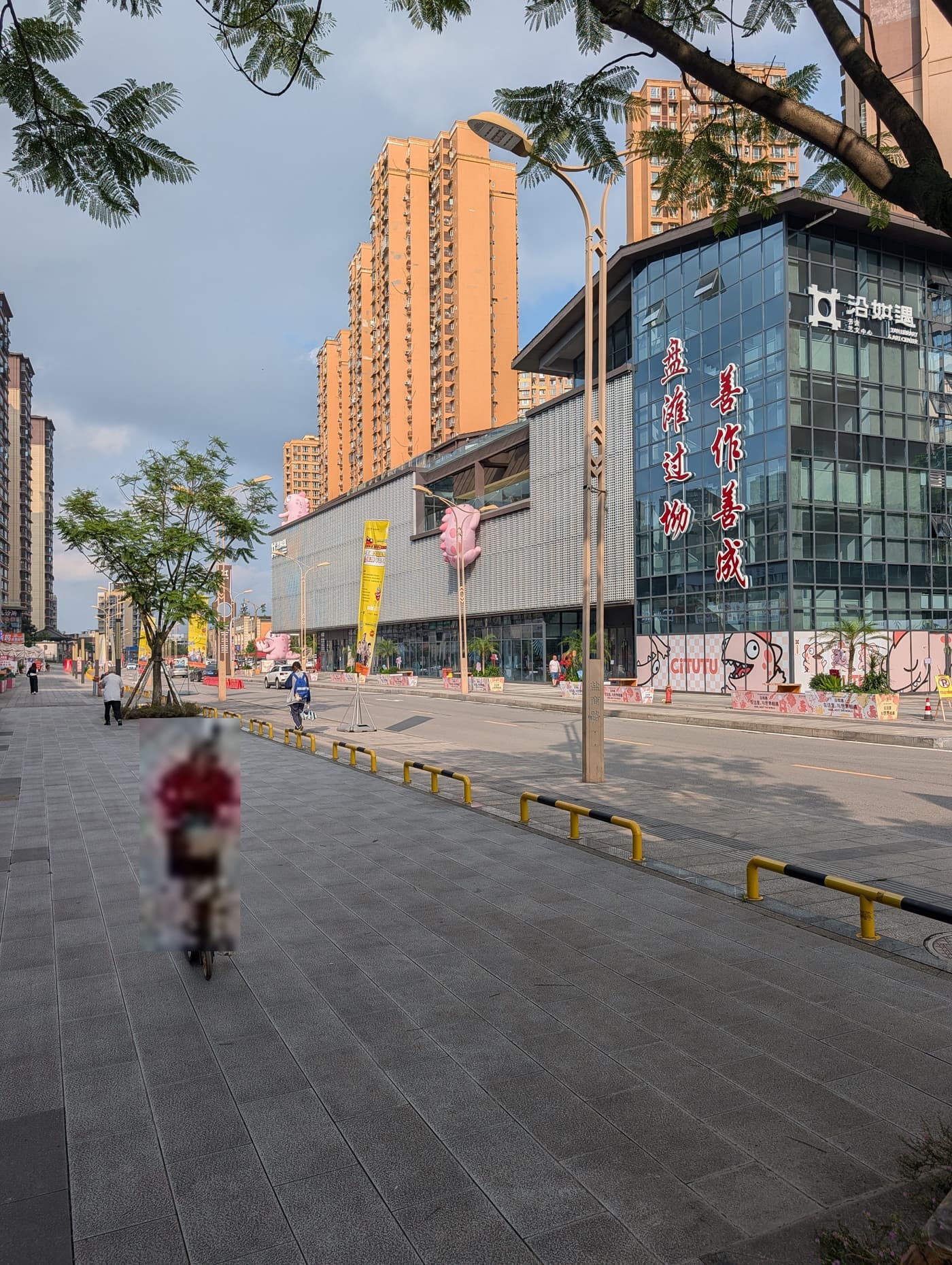 沿滩区沿如遇书舍艺文中心的临街一隅,广场上有人经过