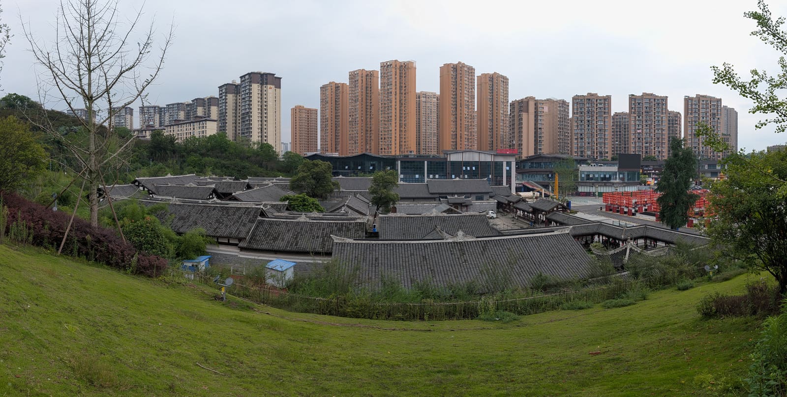王家大院的灰瓦院落,背后是成排的高层住宅